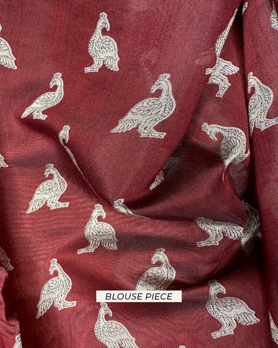 Maroon unstitched blouse piece featuring white peacock prints to coordinate with the Earthy Brown Rajathee Saree.
