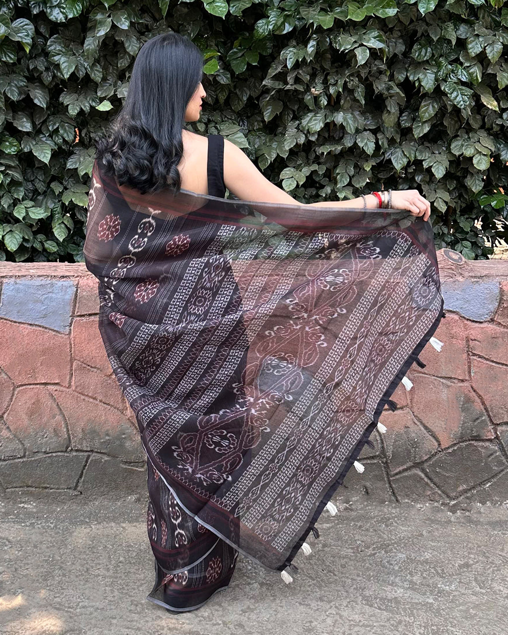 Elegant back view of Rajathee Saree Black Cotton Super Net showcasing the intricate Patola print and graceful fall.