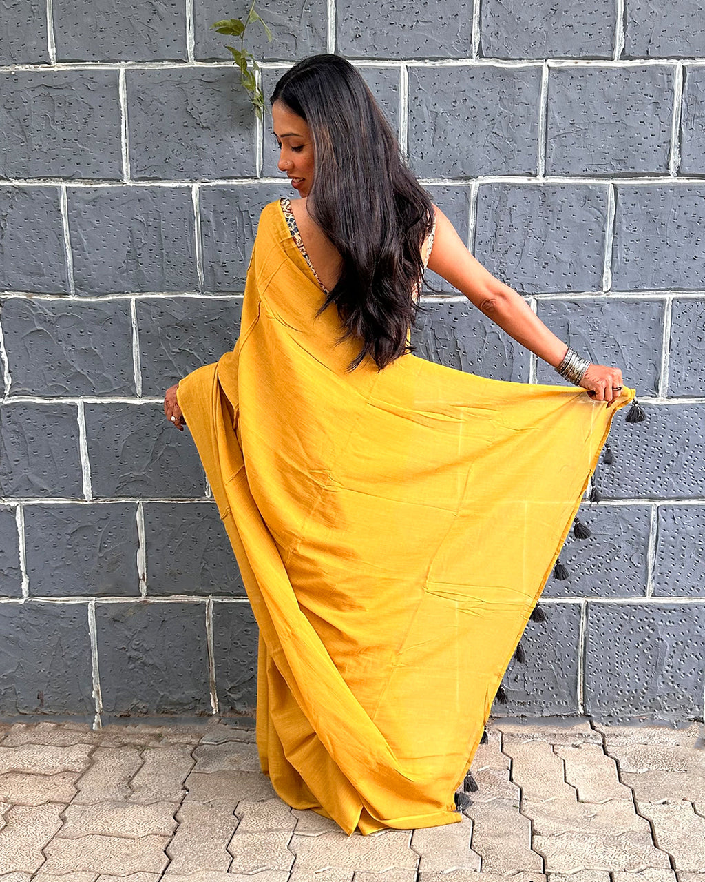 Back view of the Rajathee Saree Mustard Yellow Mul Cotton Saree with breathable fabric and dark tassel detailing.
