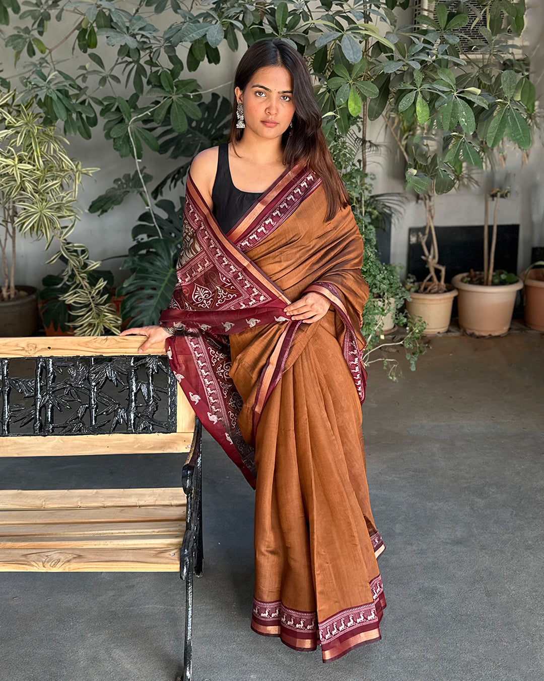 Detailed view of the intricate peacock motif pallu on the Earthy Brown Cambric Silk Saree from Rajathee Saree.