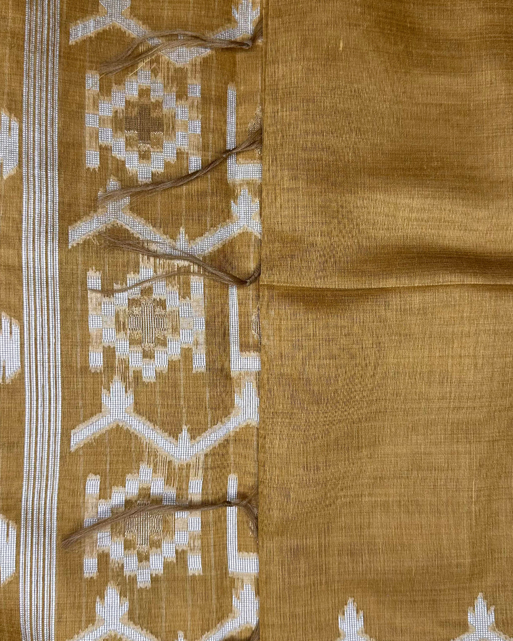 Close-up of the intricate geometric line pattern and border on the Mustard Yellow Tussar Silk fabric.