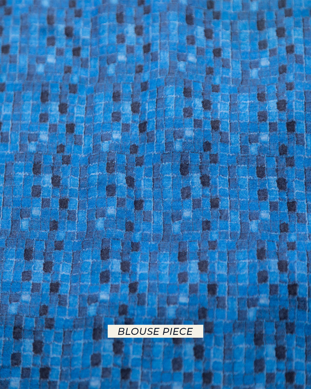 A top-down view of the matching blue blouse piece featuring a modern geometric pattern to complement the denim-inspired saree.