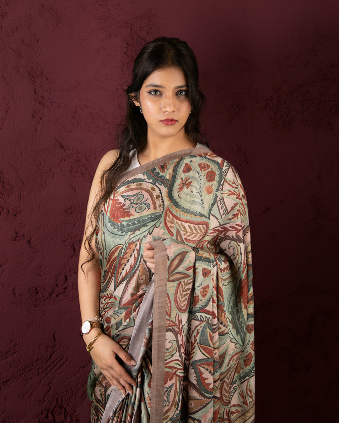 A woman models the Rustic Drape Saree in a rich, earthy brown hue, artfully draped to showcase its texture.