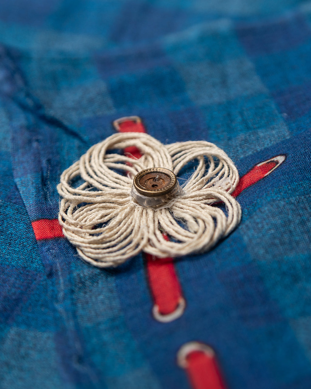 Close-up of the intricate handmade contrast thread motif and subtle check design on the Blue Mul Cotton Saree.