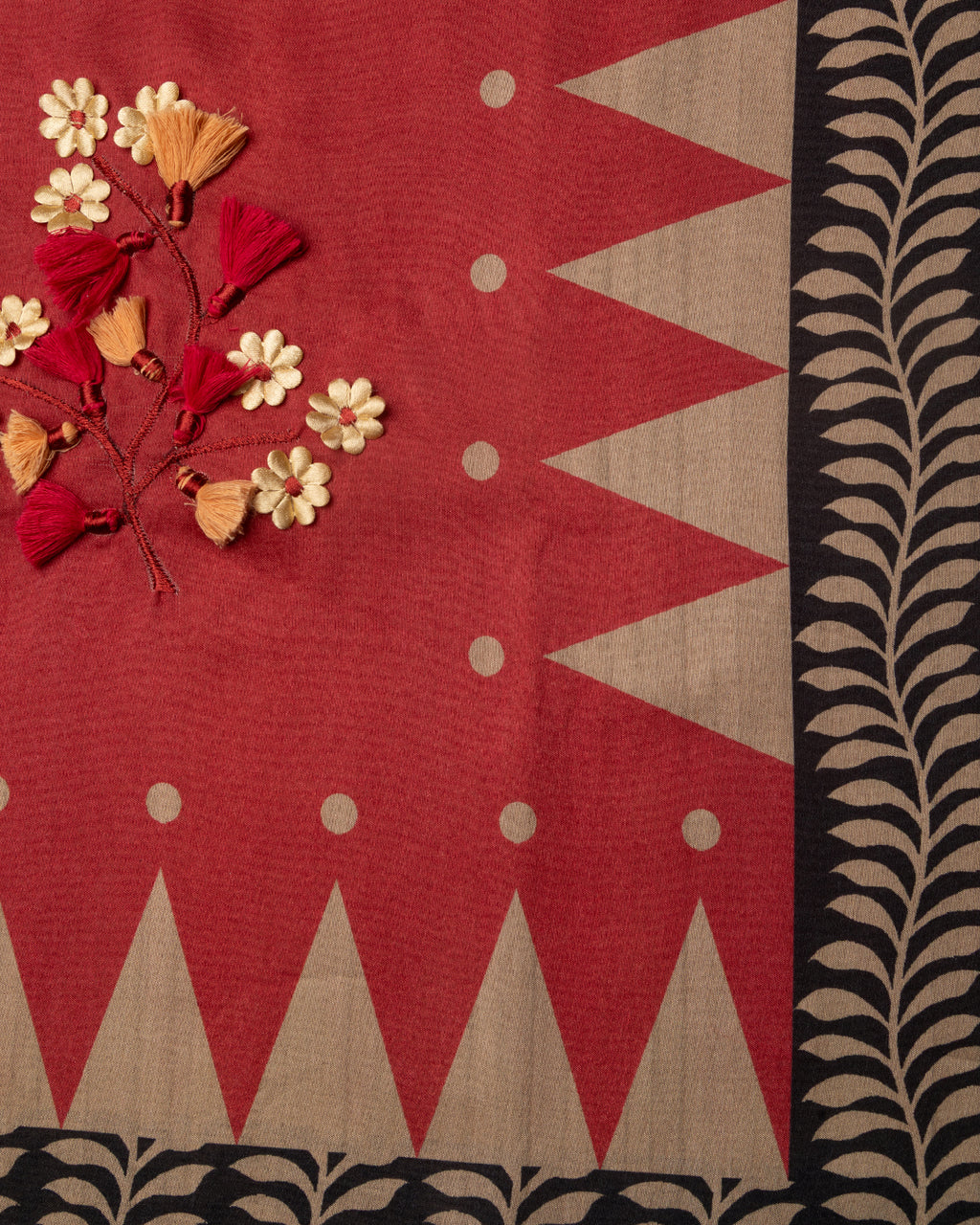 Close-up of the delicate handcrafted floral work and contrast geometric border on the Red Raw Silk fabric.