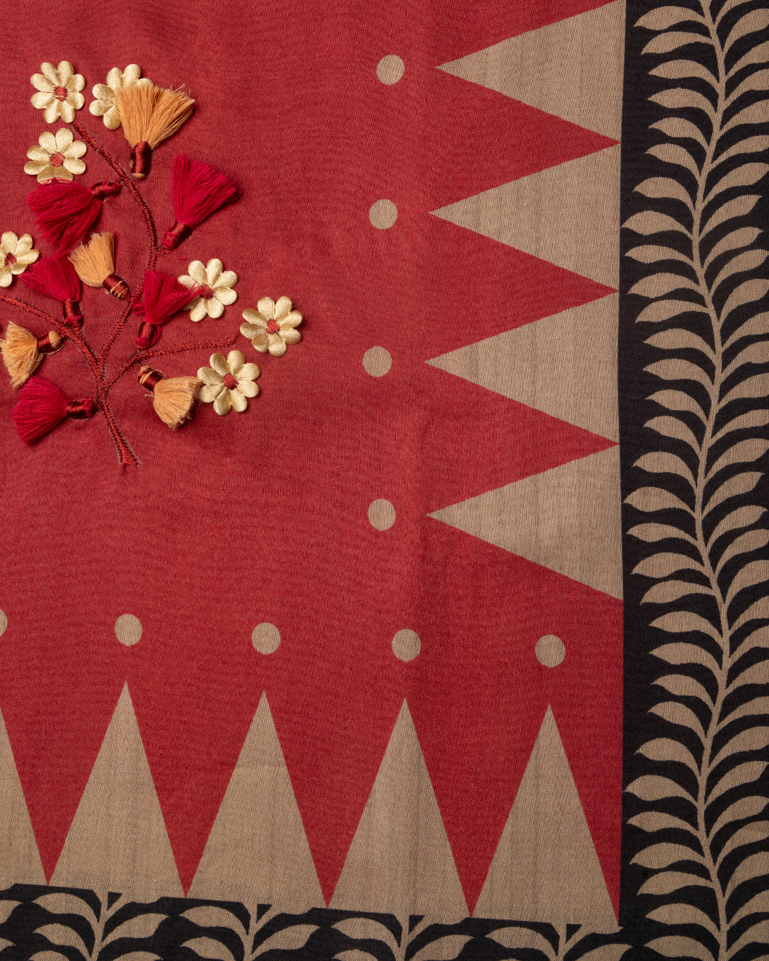 Close-up of the delicate handcrafted floral work and contrast geometric border on the Red Raw Silk fabric.
