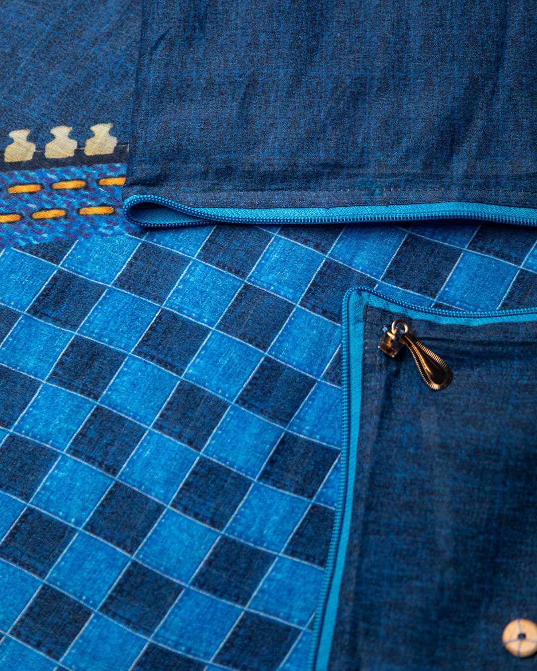Close-up of the unique blue checkered pattern and modern zip detailing on the breathable Mul Cotton fabric.