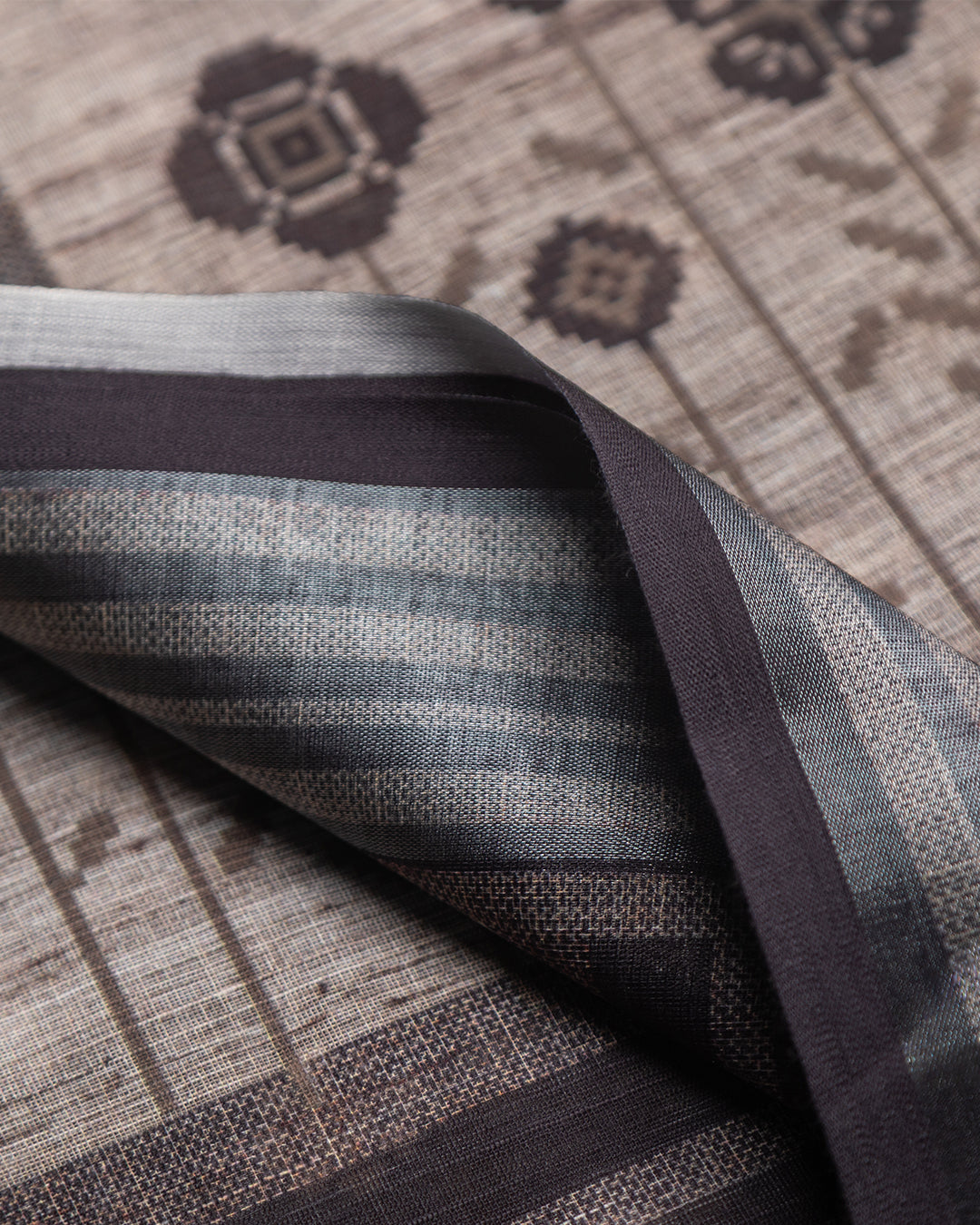 Detailed view of the striped border and coordinating black and white tassels on the Grey Cotton Saree.