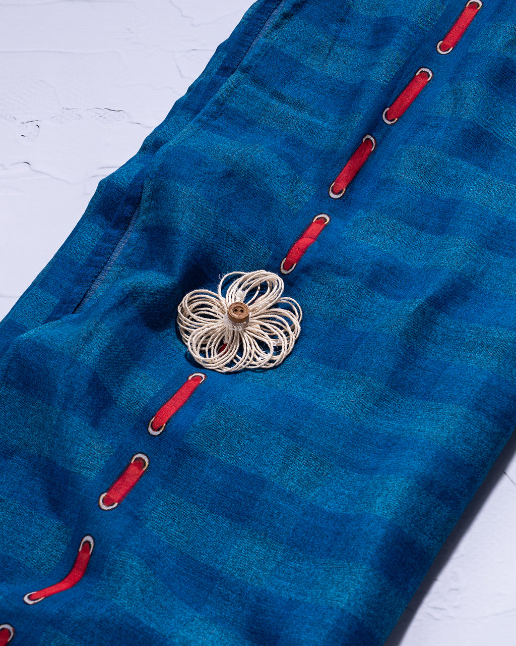 Detailed view of the red thread accents and modern check pattern on the Rajathee Saree Blue Mul Cotton.