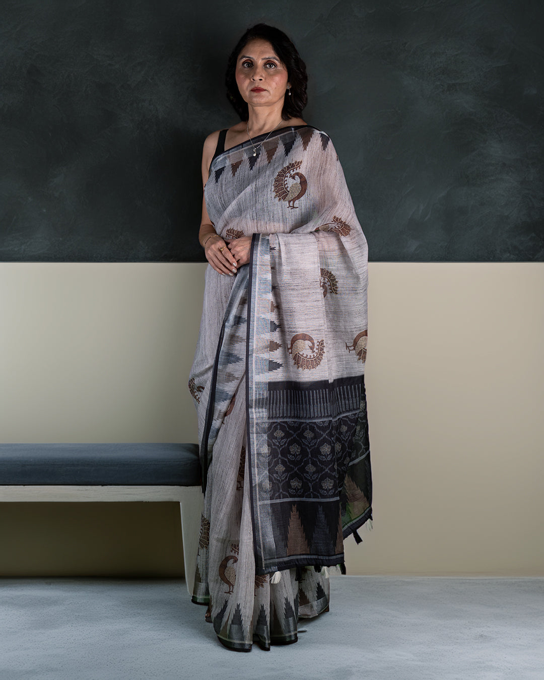 Manika Morpankh Saree: A woman models a stunning peacock blue silk saree with intricate gold embroidery.