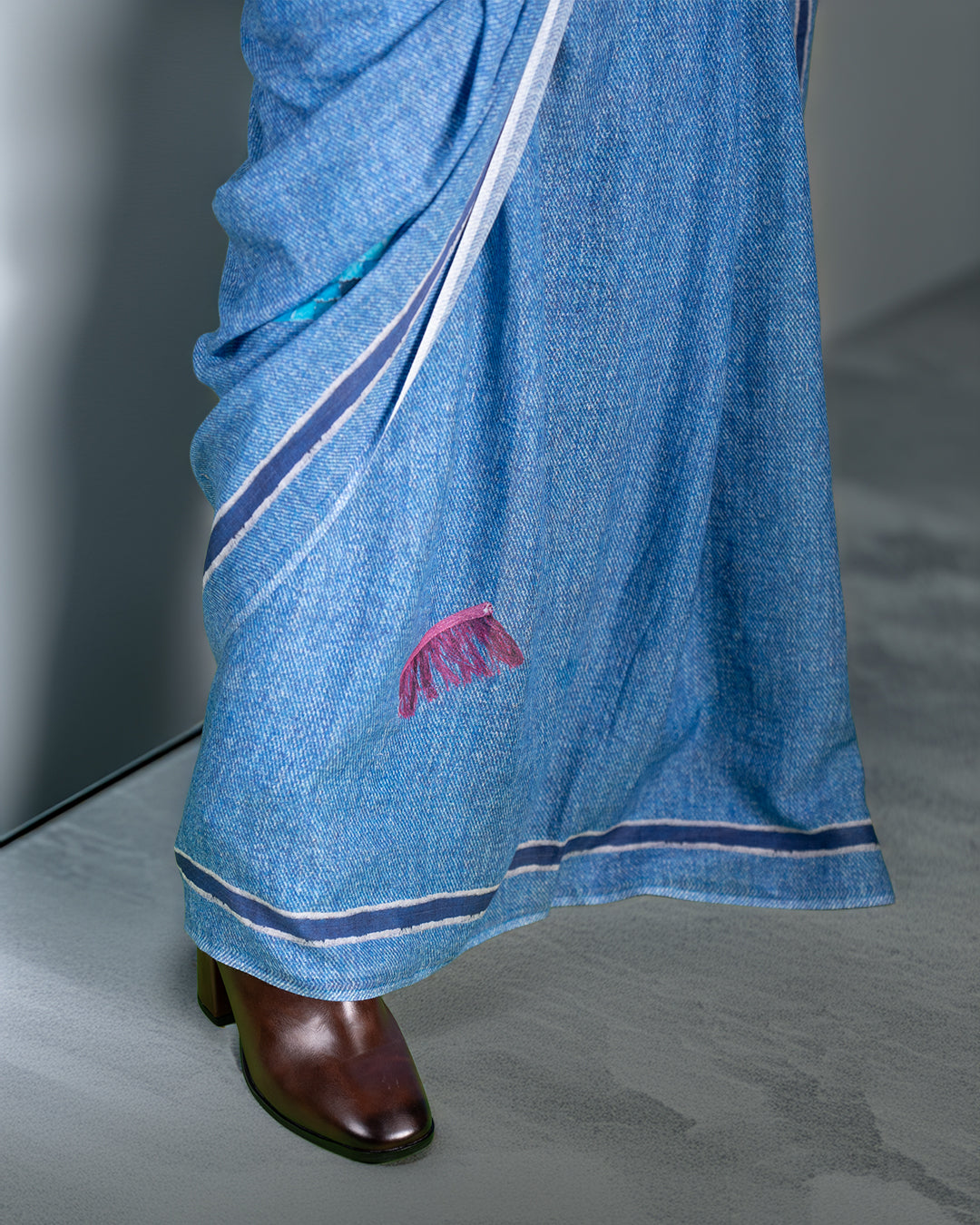 A detail shot of the saree’s lower drape highlighting the structured fall and delicate handcrafted embroidery near the hem.
