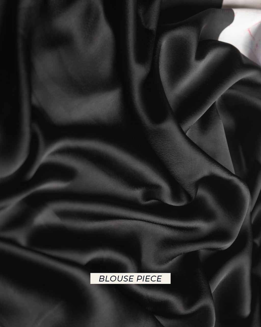 Close-up detail of the premium solid black crepe fabric included as the matching blouse piece.