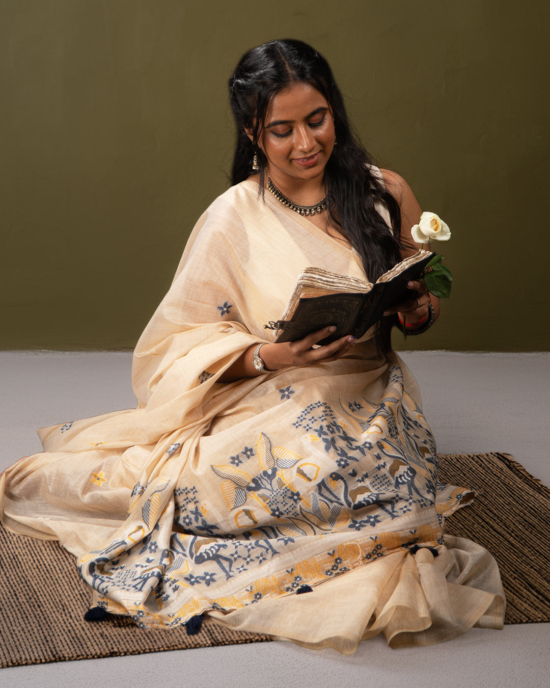 A woman in a vibrant Flamingo Saree with intricate gold embroidery, posing elegantly.