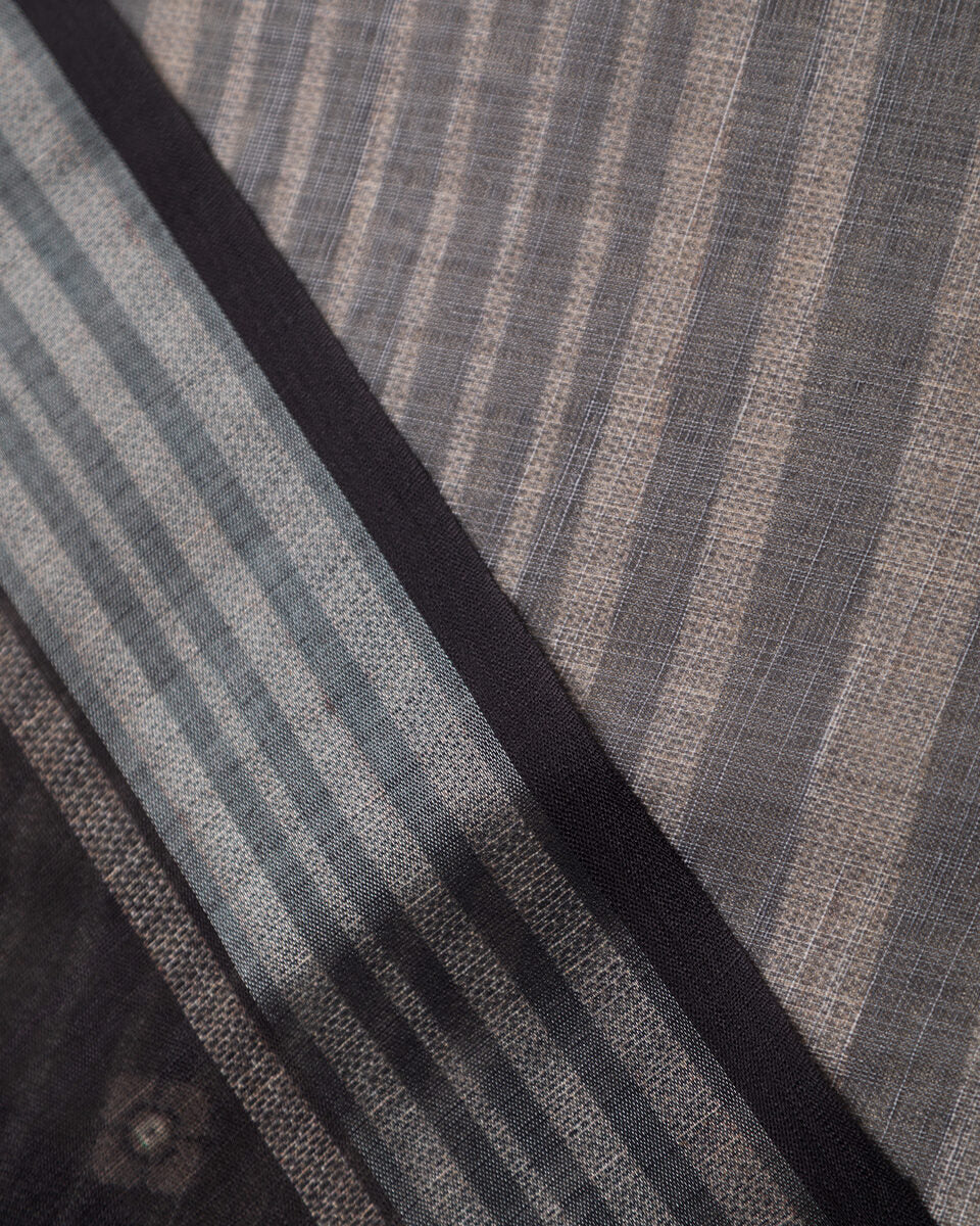 A detailed view of the black and grey striped border on the structured cotton fabric, showing the fine weave.