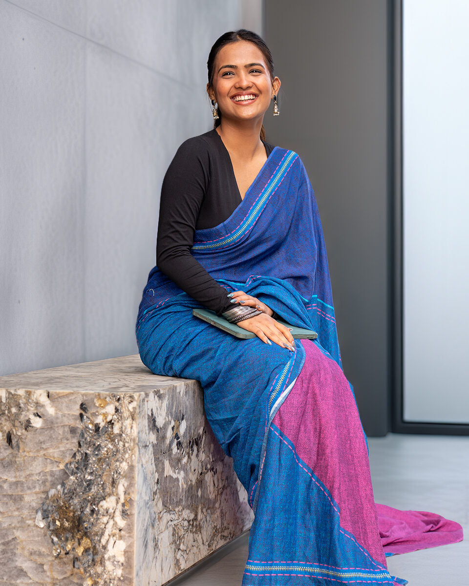 Elegant seated view of the Blue Mul Cotton Saree by Rajathee Saree highlighting the soft, breathable texture.