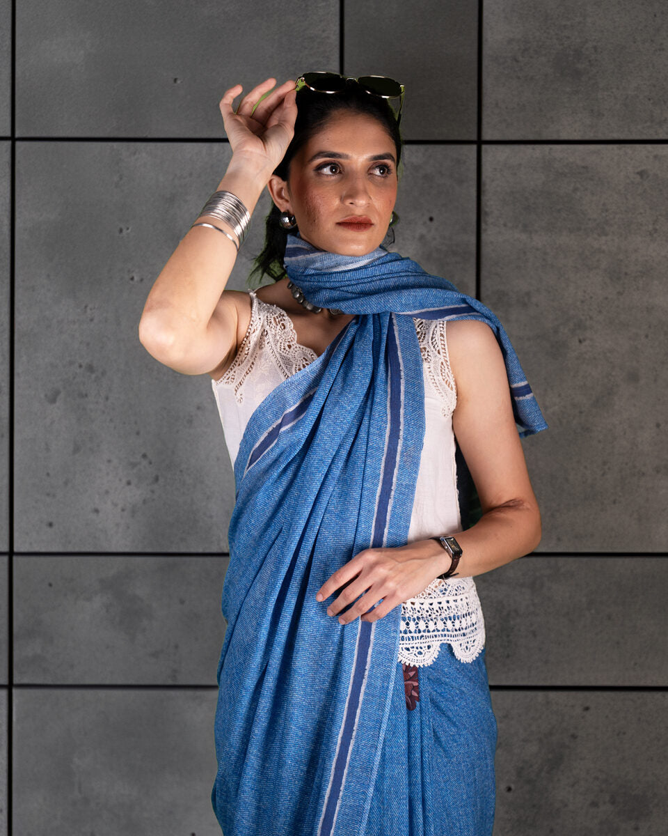 A model showcasing the soft, breathable texture and sophisticated drape of the denim-blue Mul cotton saree.