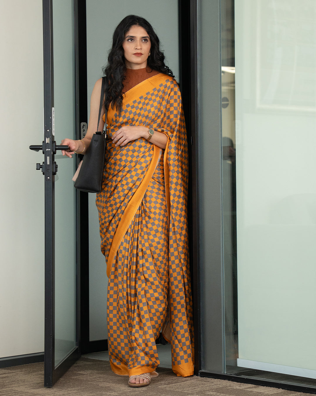 Queen's Grid Saree with intricate gold patterns on a rich red silk fabric.