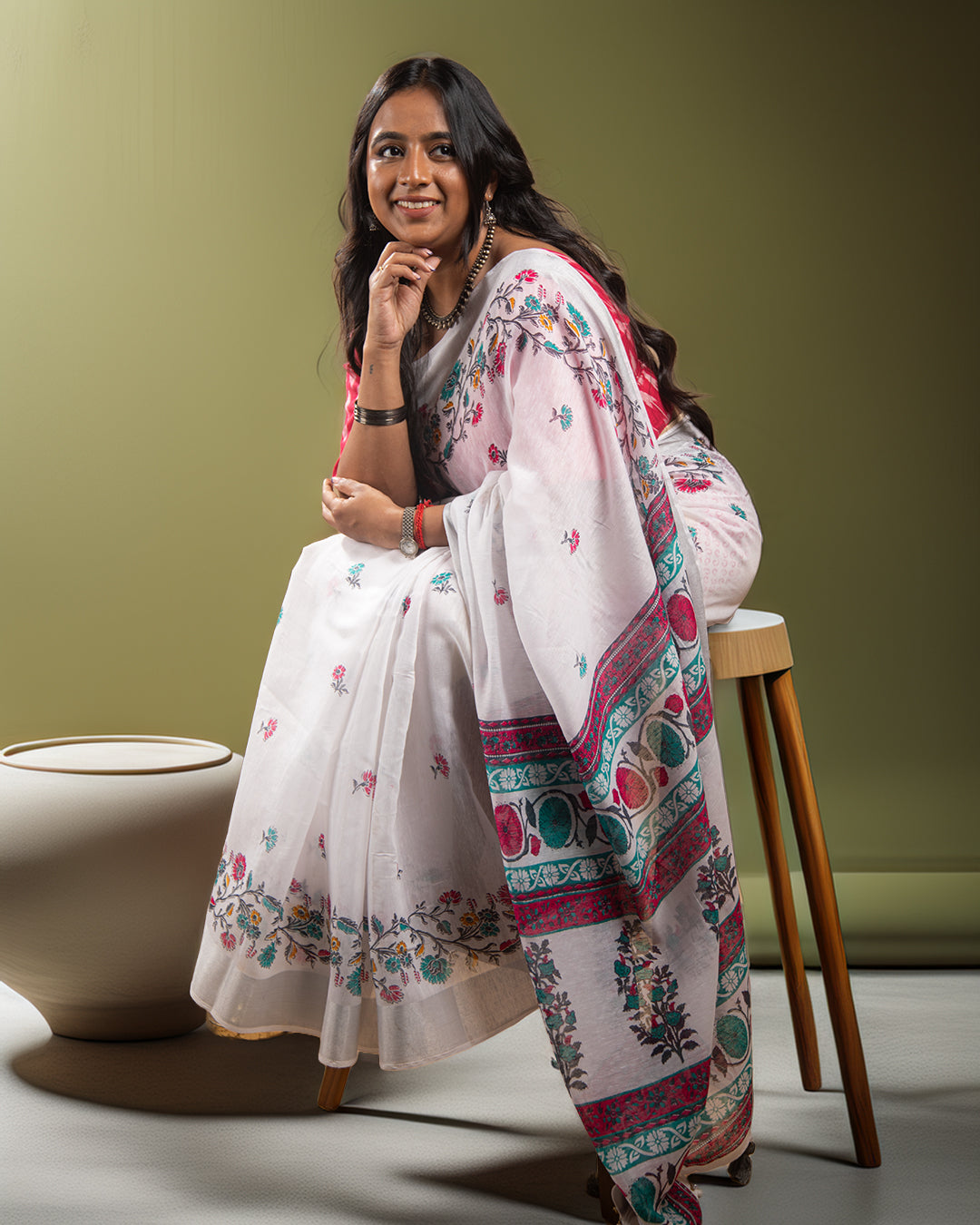 An abstract floral pattern in pink and green, featured on a Rajathee product.